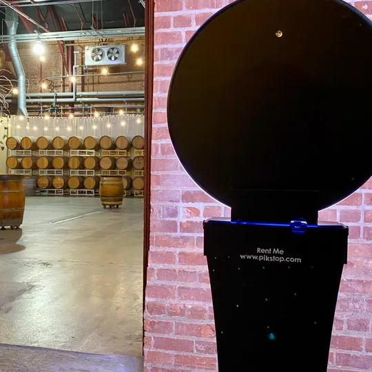 Pik Stop photo booth set up against the brick and barrels at Rendez-vous Winery